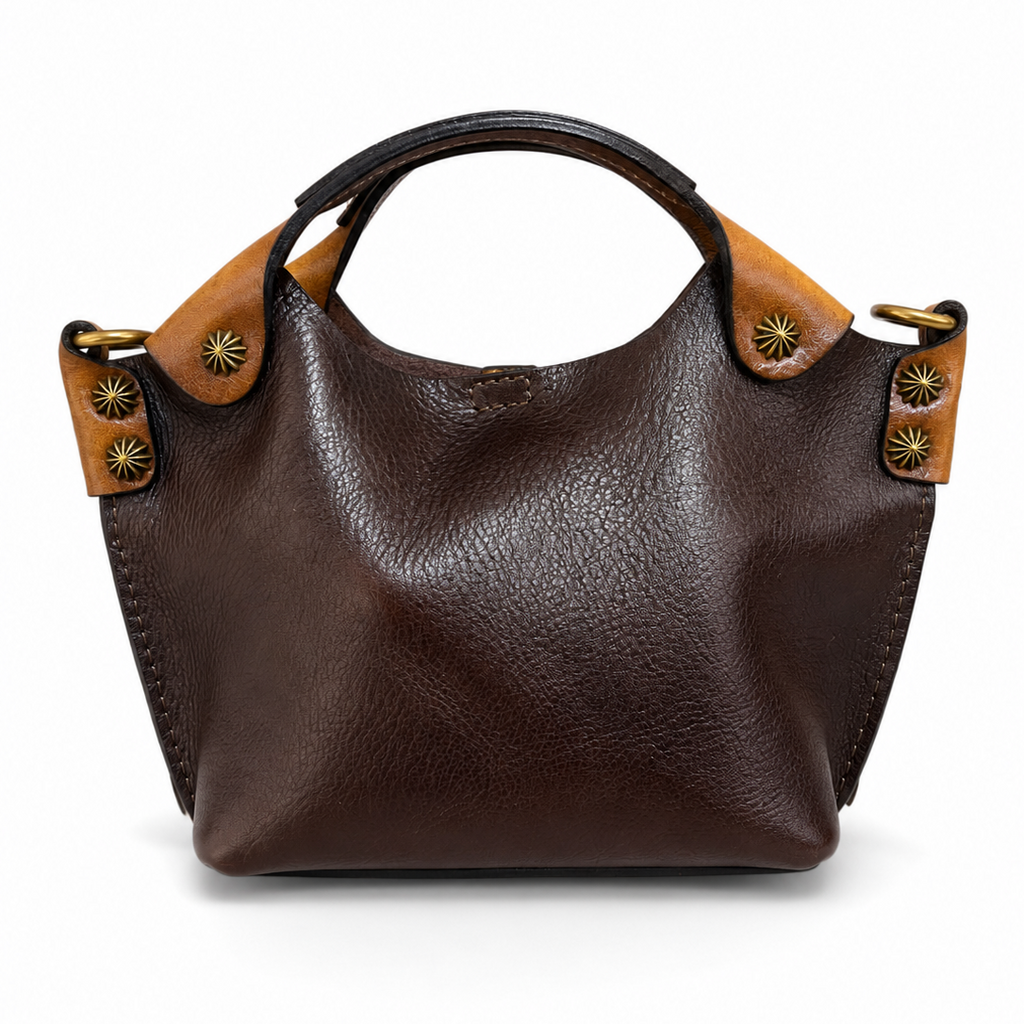 Brown leather handbag with decorative straps on a white background