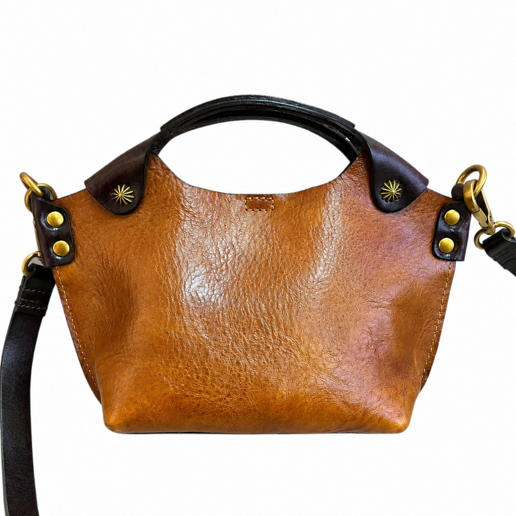 Brown leather handbag with black accents on a white background