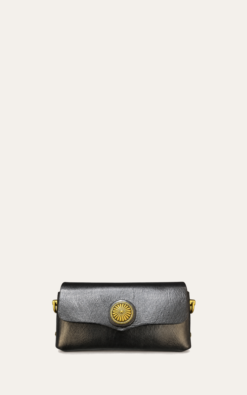 A small leather clutch bag with a dark gray top flap and black body, featuring a prominent gold sunburst button clasp and gold side hardware, set against a solid off-white background.