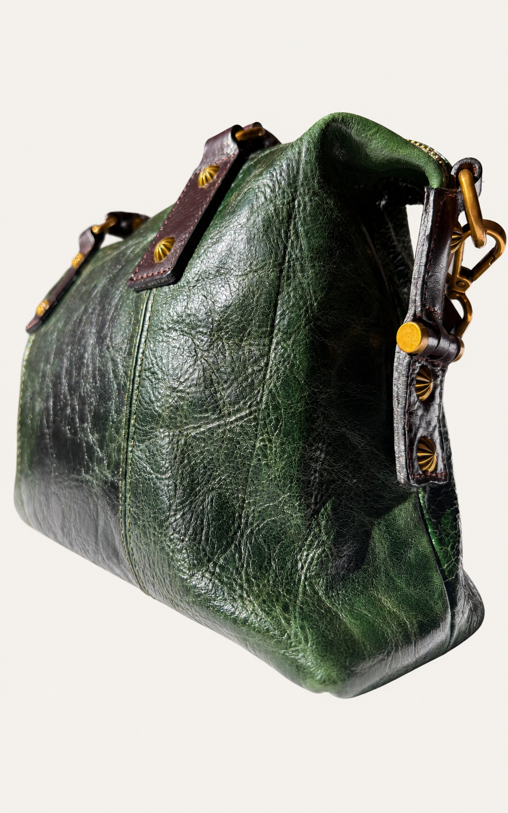 A distressed dark green leather shoulder bag with brown leather straps and gold-tone hardware, shown on a light off-white background.