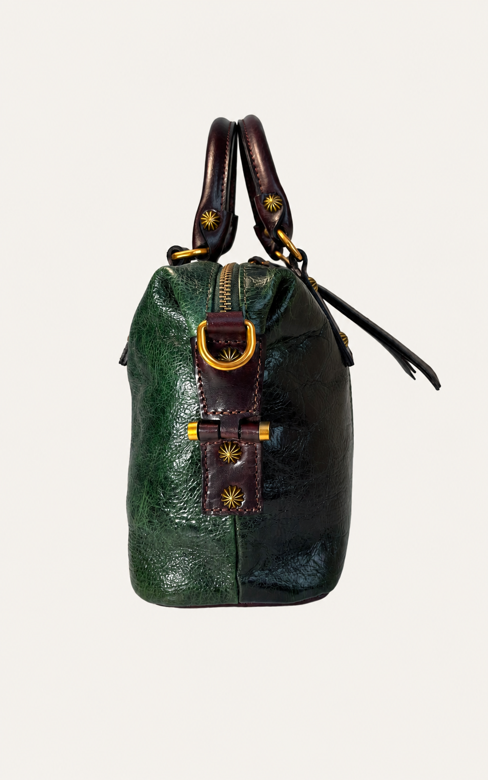 A small leather handbag with a split green and black body, dark brown handles and front strap, and gold-tone hardware, shown against a plain light background.