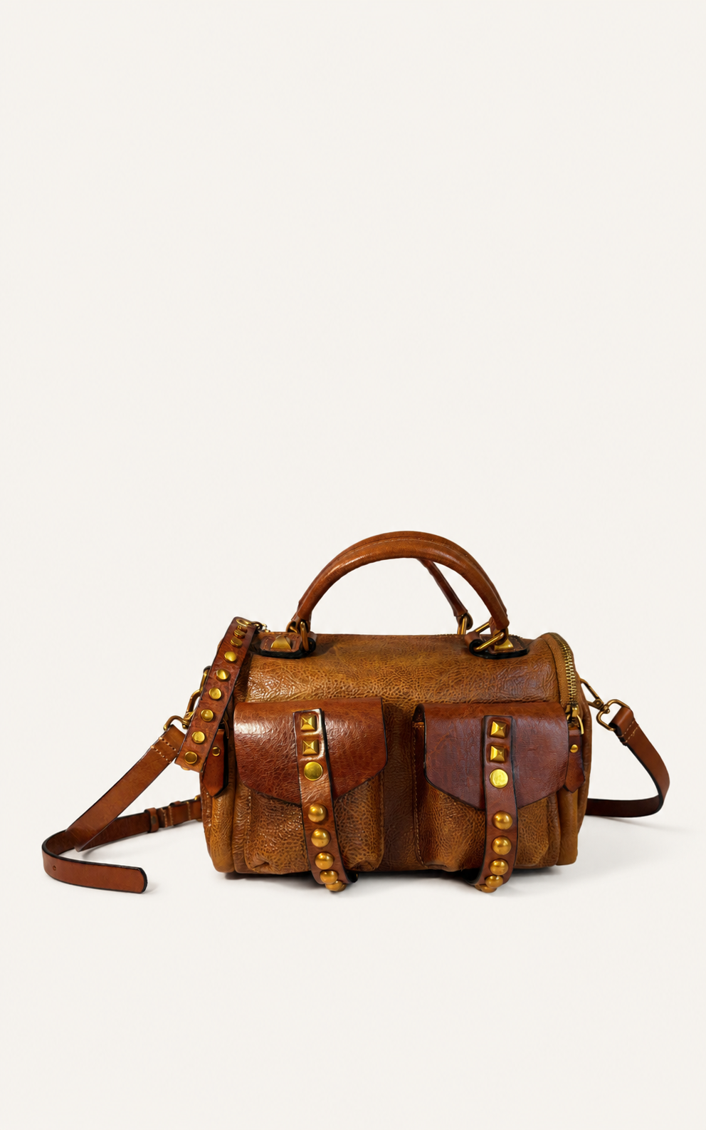 A brown leather handbag with a top handle, shoulder strap, and decorative gold-tone studs and rivets, photographed against a plain off-white background.